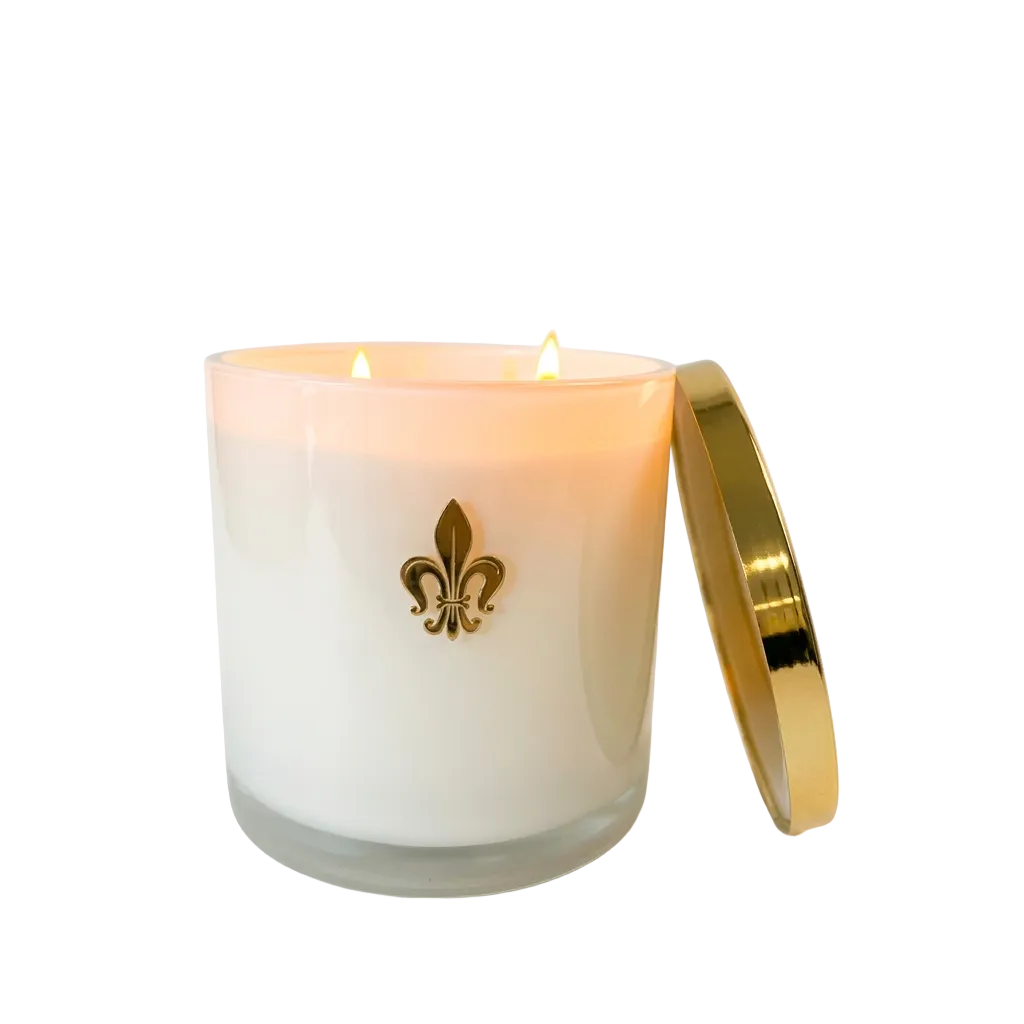 White candle with a gold lid and fleur-de-lis emblem on a white background